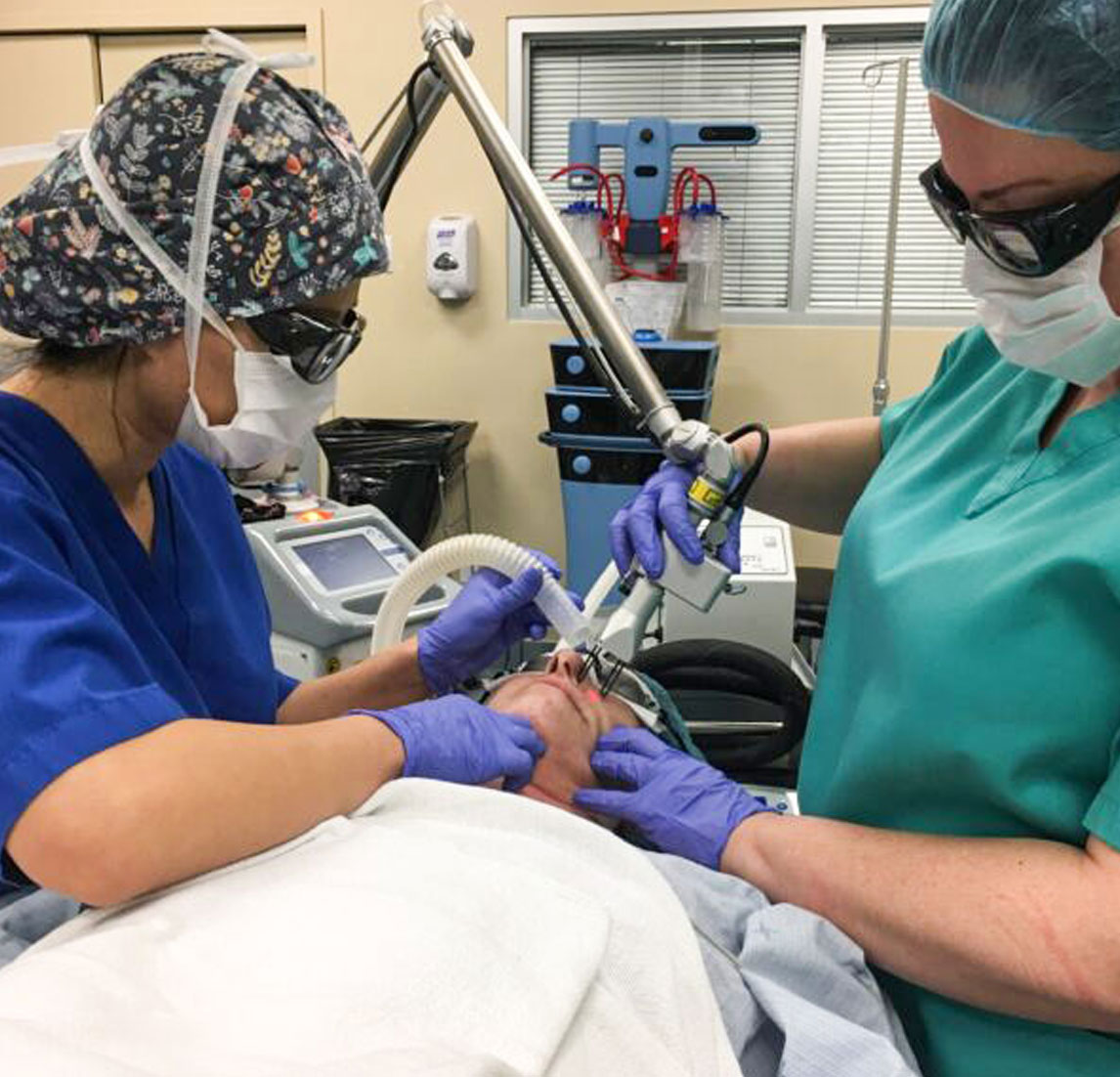 Technicians performing smartskin laser treatment on patient
